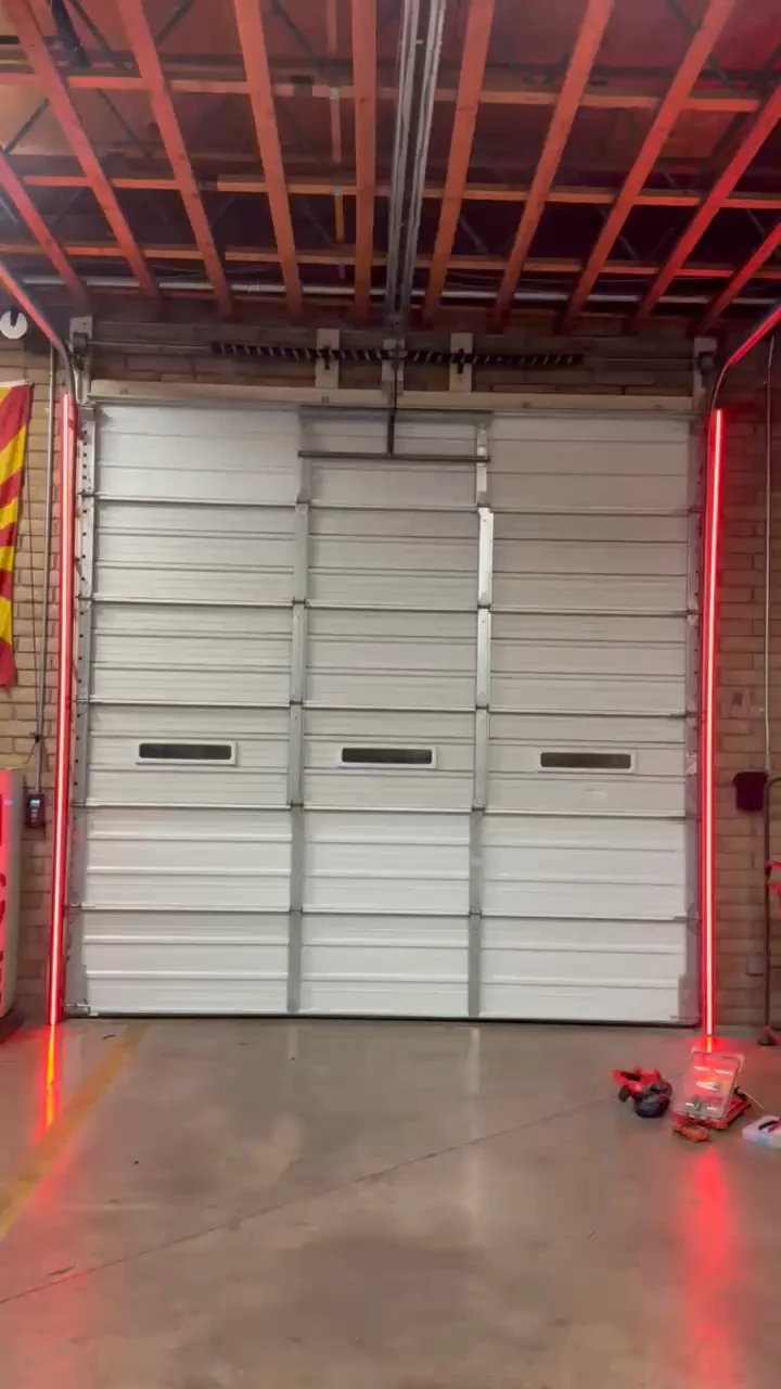 Real DoorShield installation with red LED bars beside a closed fire station bay door
